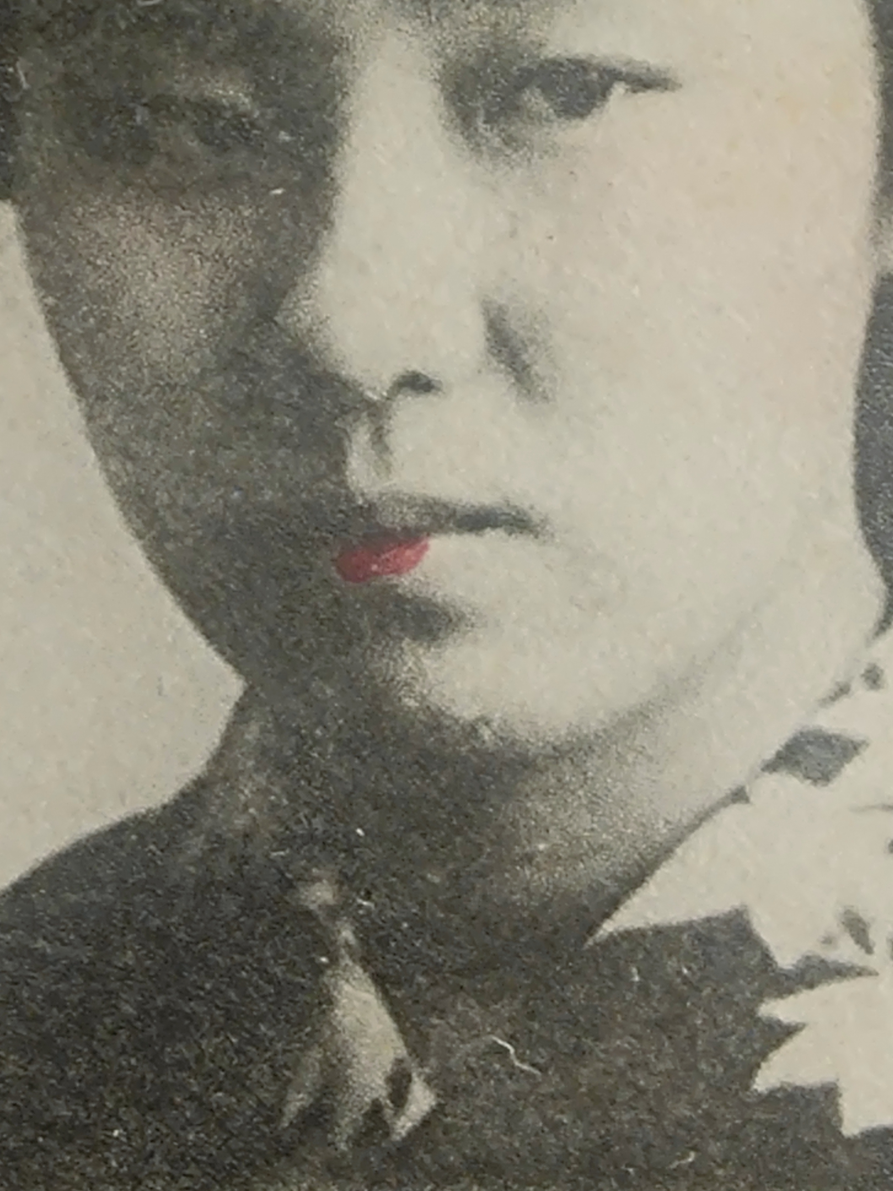 Close-up of lip colouring on the postcard: pale red applied by brush
